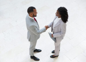 HR manager welcoming successful candidate HR manager welcoming successful candidate in office hallway. Business man and woman standing and shaking hands. Hiring concept